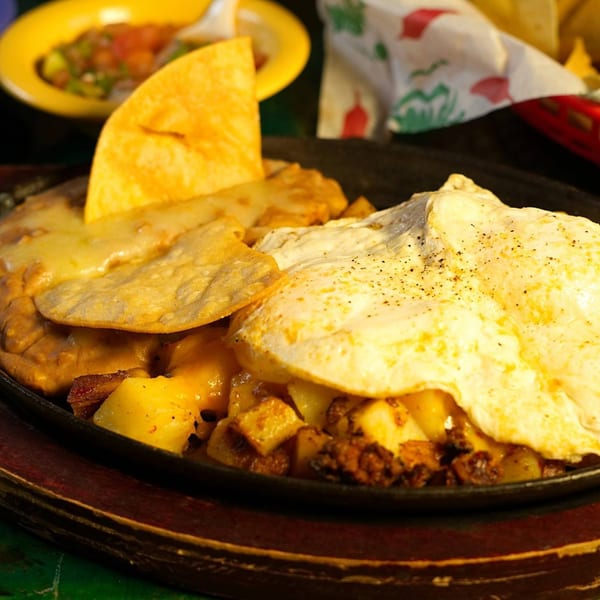 La Morena's Mexican breakfast skillet with fried eggs, potatoes, chorizo, and cheesy tortillas.